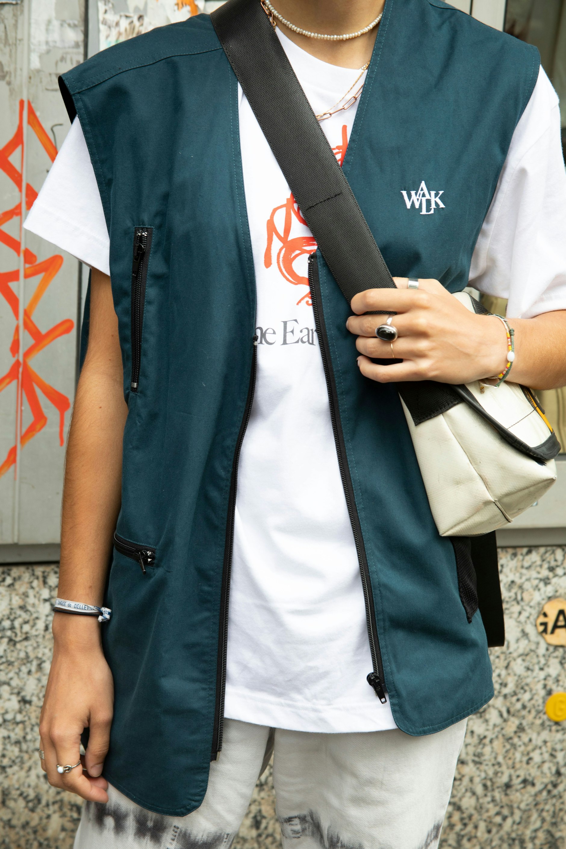 Zum Uniqlo-T-Shirt kombiniert Eugenie eine Funktionsweste der Marke Walk in Paris. Die Jeans in Batik-Optik ist von Monki, dazu trägt sie Dr. Martens.