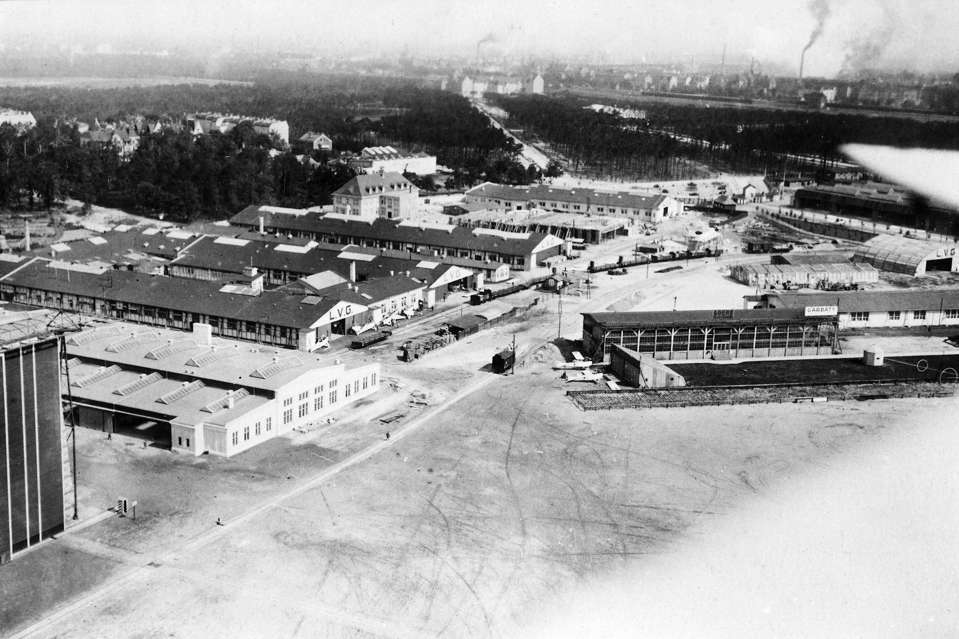 Blick auf die Randbebauung am Flugplatz Johannisthal, wo in den Werkshallen der LVG Flugzeuge produziert wurden. Durch den Versailler Vertrag nach dem Ersten Weltkrieg wurde dies verboten.