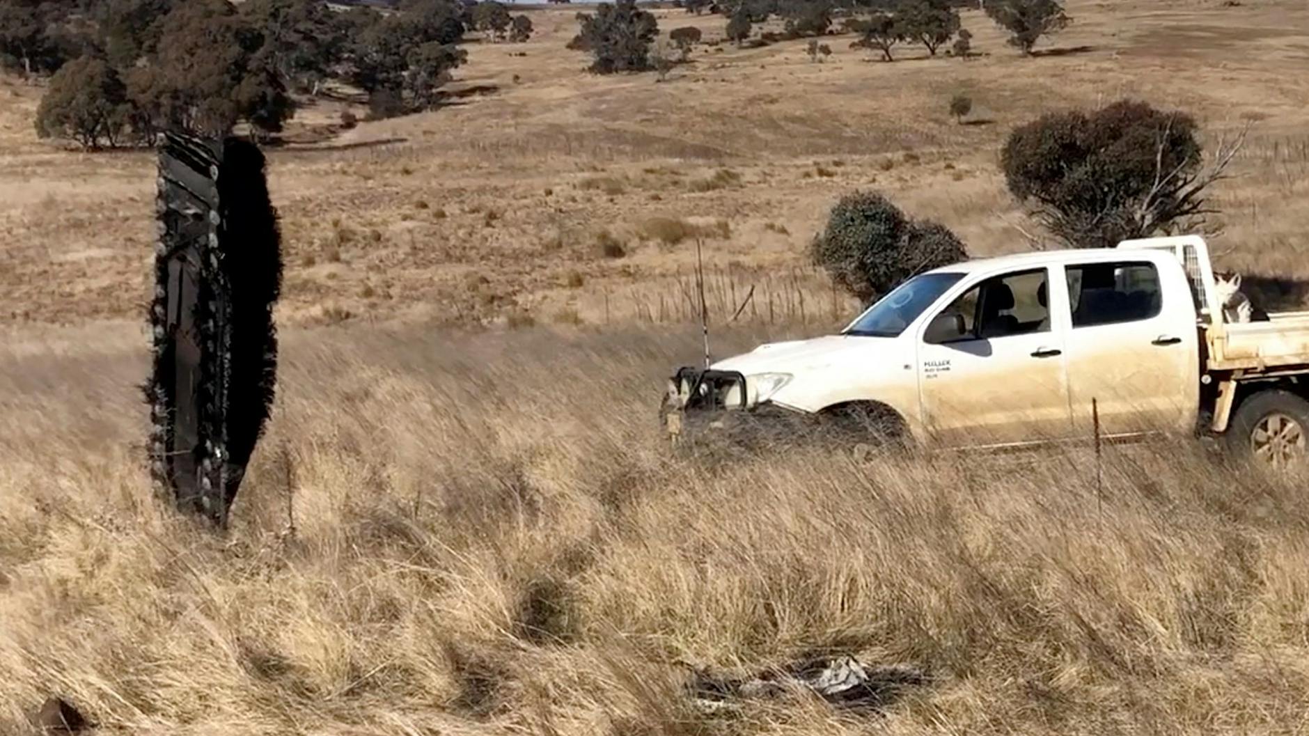 Verkohltes Raketenteil (l.) steckt in der Erde.