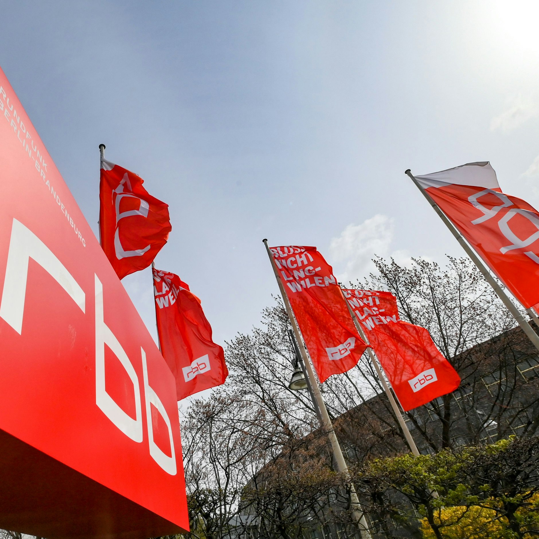 Das Logo und Fahnen des Fernsehsenders und Radiosenders Rundfunk Berlin-Brandenburg (RBB) am Standort in der Berliner Masurenallee.