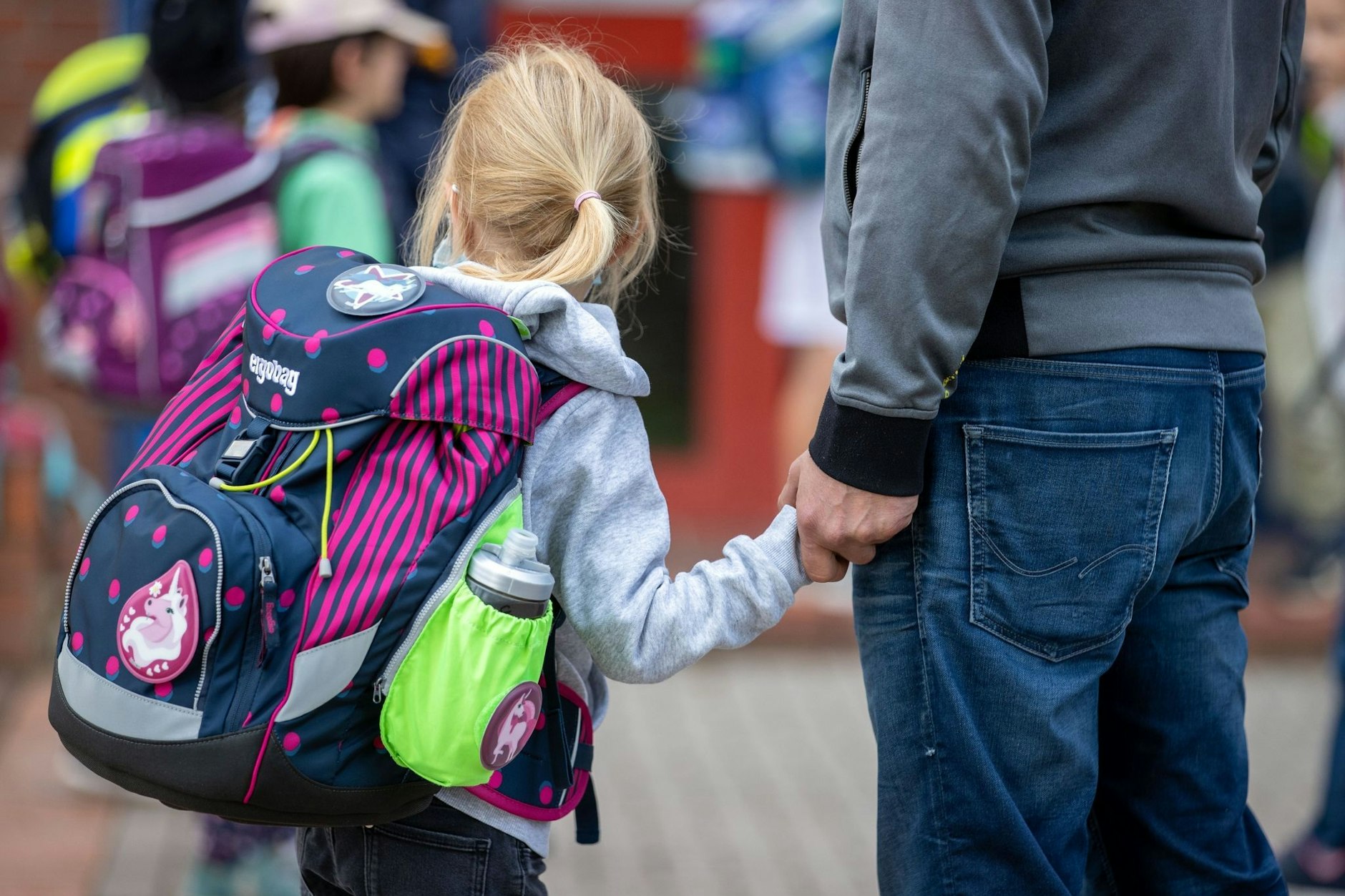 Ein Grundschulkind wird zur Schule gebracht.