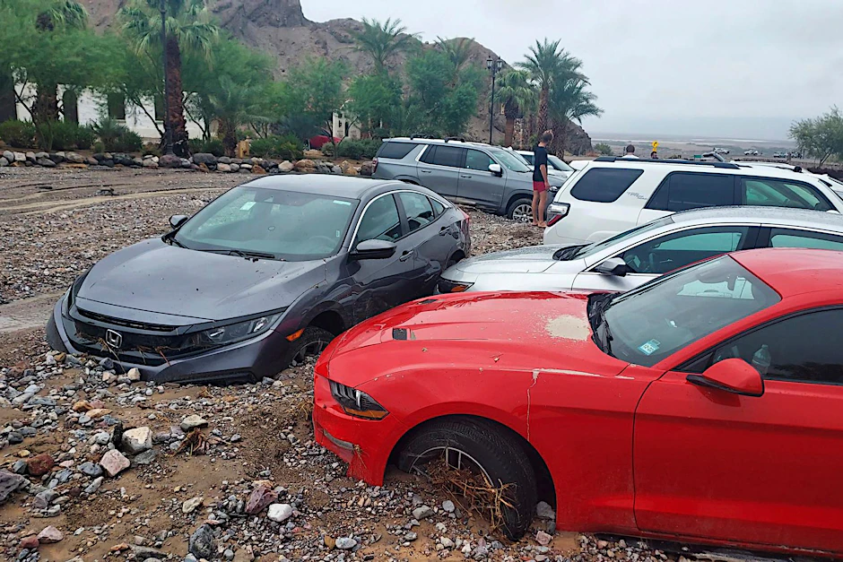 HANDOUT - Autos stecken nach einer Sturzflut im Death Valley im Schlamm und Geröll fest.  /dpa