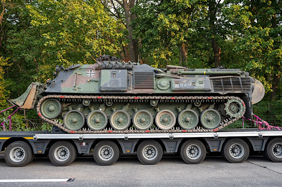 Ein Pionierpanzer Dachs der Bundeswehr steht in der Nähe der Brandstelle.  