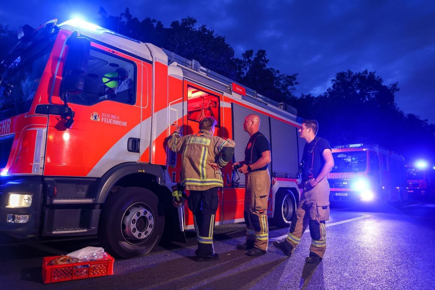 Feuerwehrfahrzeuge stehen mit Blaulicht auf einer Abfahrt der Autobahn 115, der Avus.