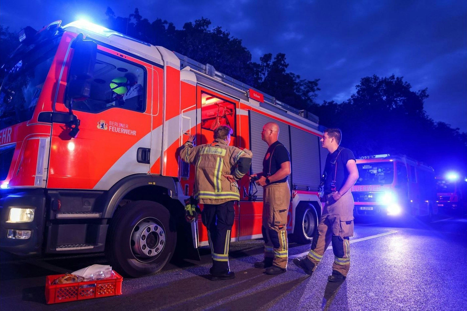 Feuerwehrfahrzeuge stehen mit Blaulicht auf einer Abfahrt der Autobahn 115, der Avus.