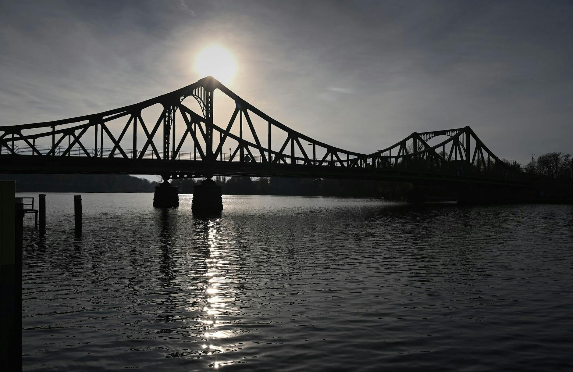 ARCHIV - Die Sonne geht vor der Veranstaltung zum Gedenken an die Wiedereröffnung der Glienicker Brücke unter. d/Archivbild