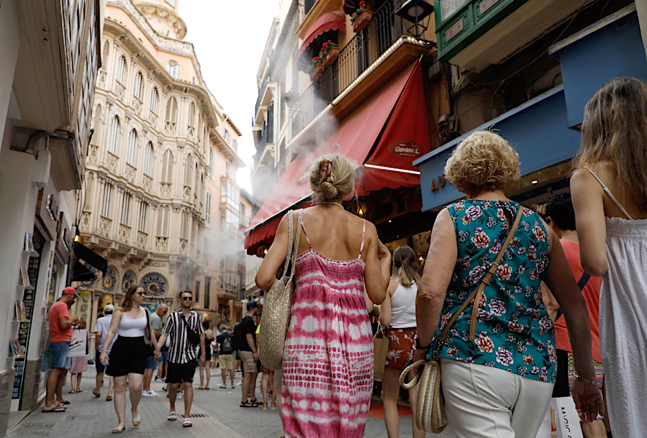 Touristen spazieren durch die Innenstadt von Palma.