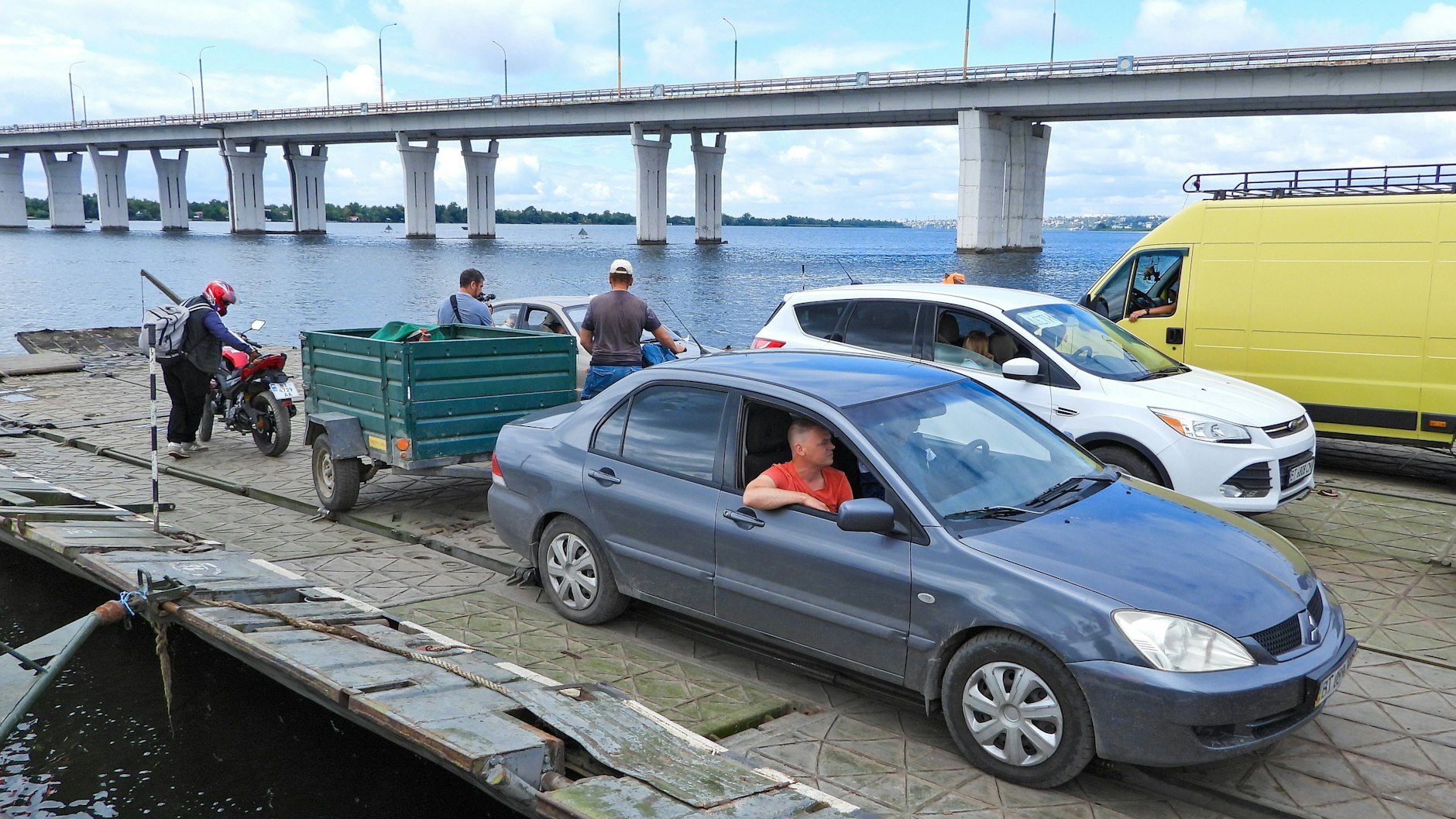 Nach ukrainischem Raketenbeschuss dieser Dnipro-Brücke in der Oblast Cherson mussten Autos auf eine Ponton-Fähre ausweichen.