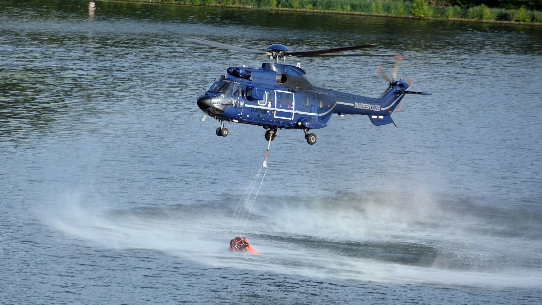 Ein Löschhubschrauber holt Wasser aus der Havel.