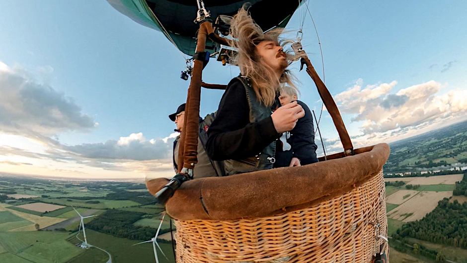 HANDOUT - Der Hamburger Musiker Johannes «Johnny» Ritter spielt im Korb eines Heißluftballons 327 Meter über dem Festivalgelände des Wacken Open Air ein Luftgitarren-Solo.  
