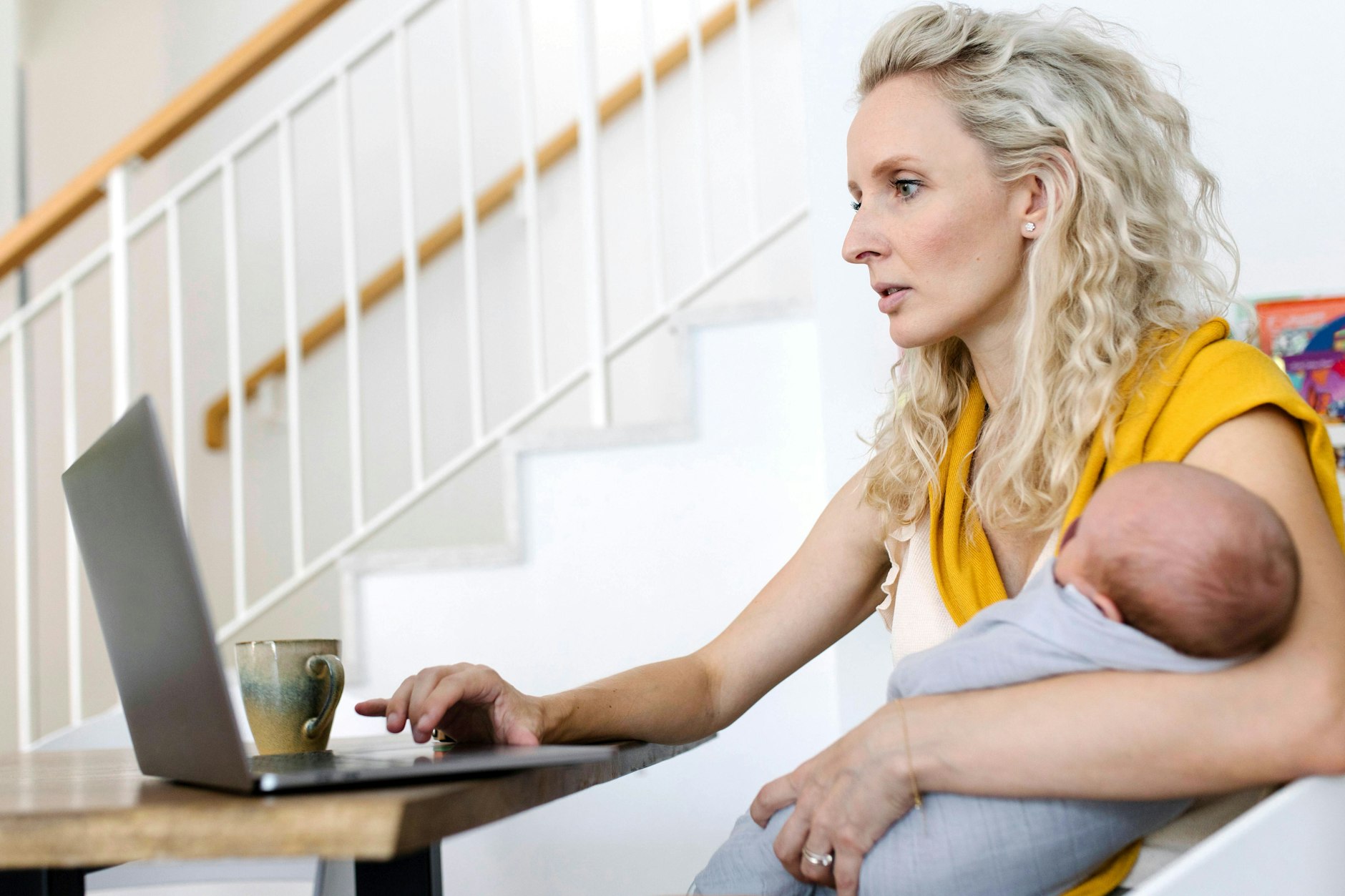 Woman carrying baby in arm working from home model released, Symbolfoto property released,