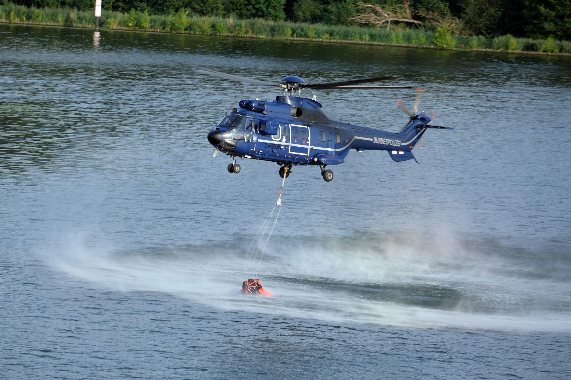 Ein Löschhubschrauber holt Wasser aus der Havel.