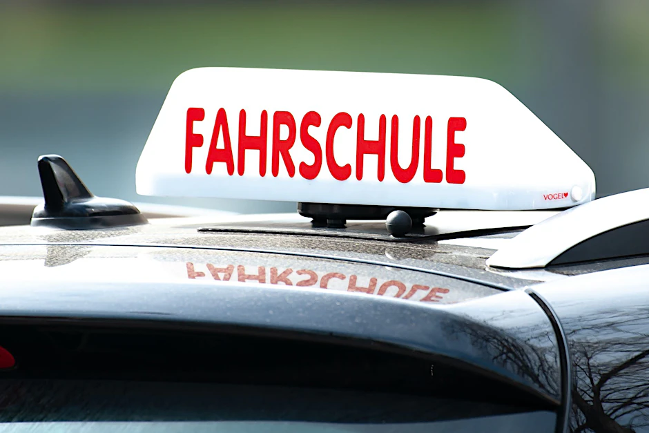 ARCHIV - Ein Schild mit der Aufschrift «Fahrschule» ist auf einem Fahrschulauto befestigt.  