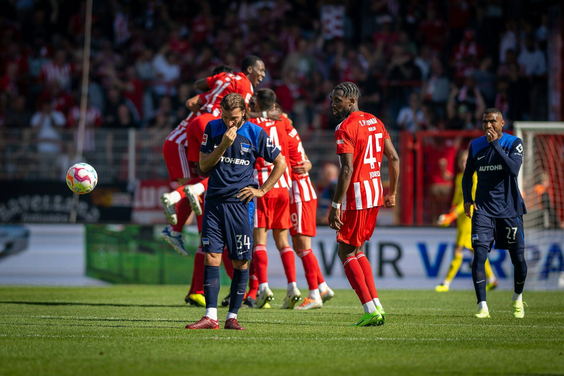 Die Spieler des 1. FC Union feiern nach dem Tor zum 3:0 durch Robin Knoche. Die Herthaner Ivan Sunjic und Kevin-Prince Boateng (r.) schieben Frust.