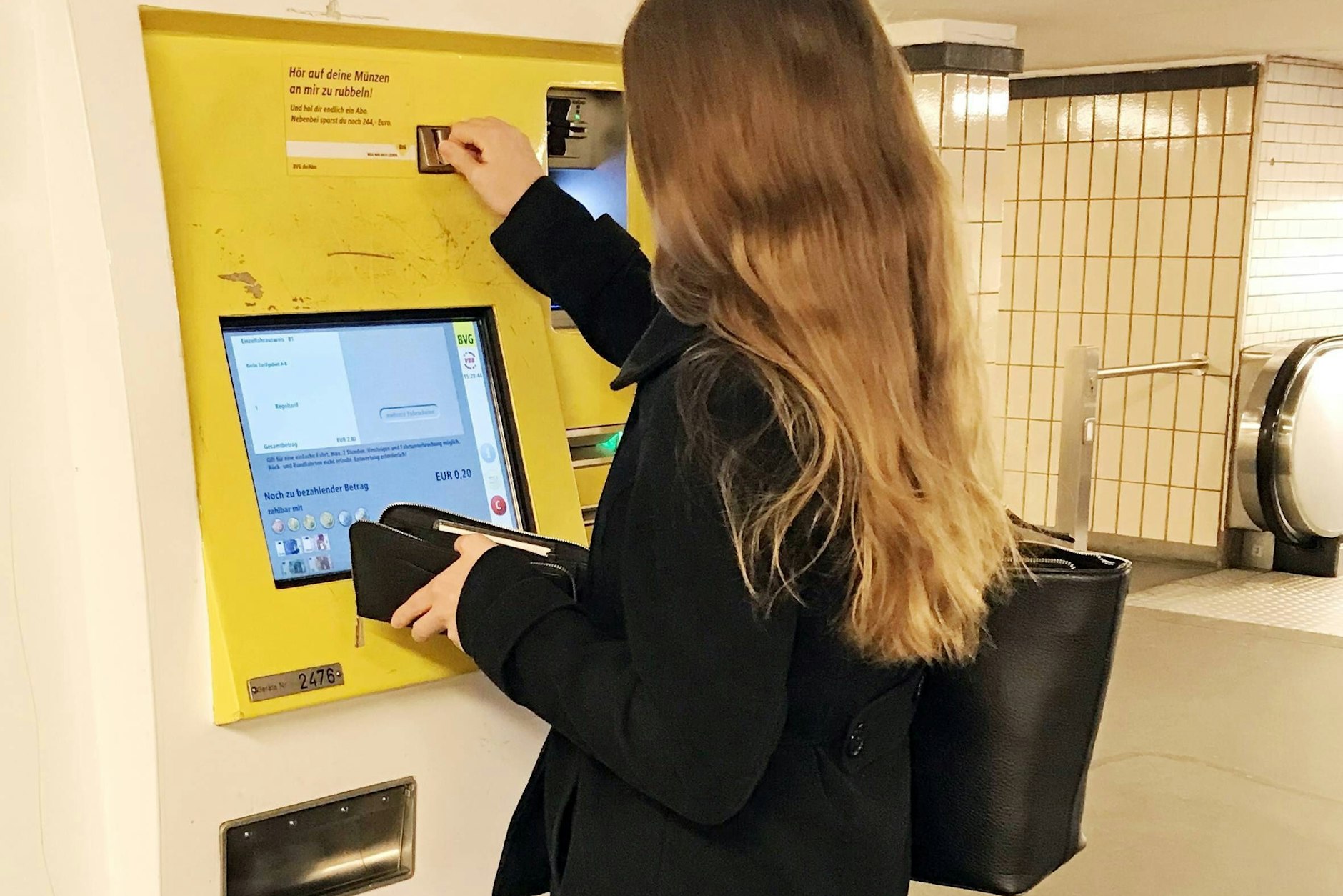 Eine BVG-Kundin löst an einem Fahrscheinautomaten ein Ticket.