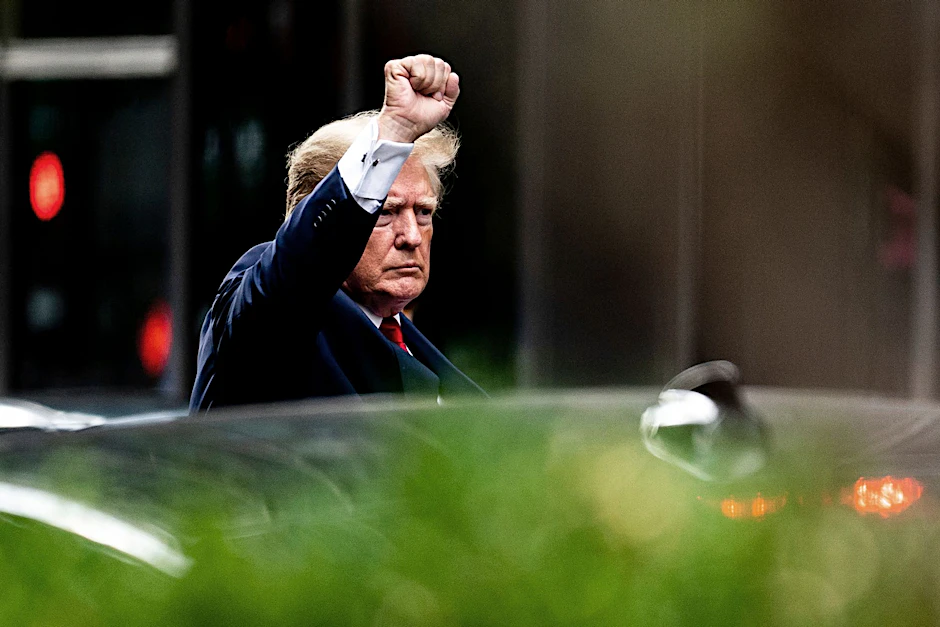 Donald Trump mit erhobener Faust auf dem Weg in das Büro der Generalstaatsanwaltschaft.