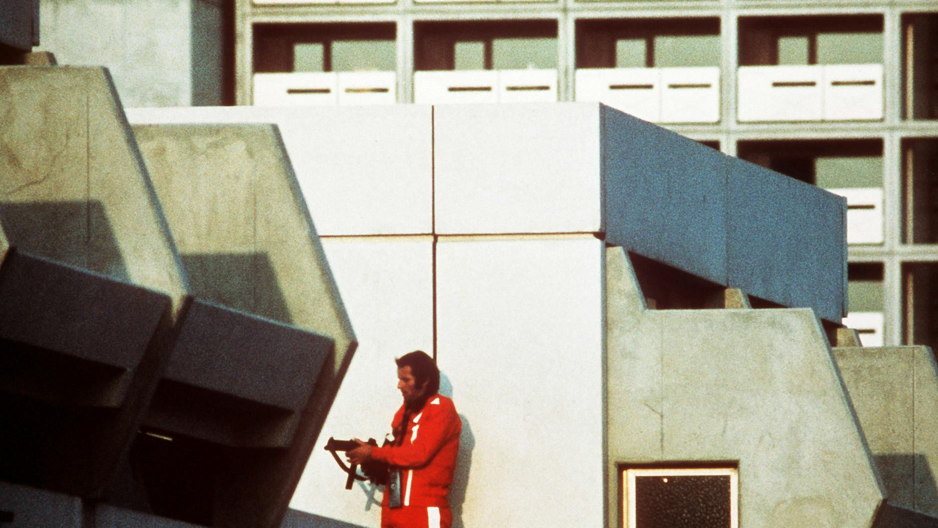 Ein bewaffneter Polizeibeamter im Trainingsanzug sichert am 5. September 1972 im Olympischen Dorf den Block, in dem Terroristen die israelischen Geiseln festhalten.