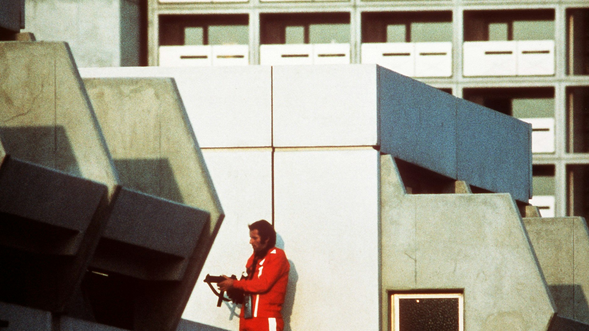 Ein bewaffneter Polizeibeamter im Trainingsanzug sichert am 5. September 1972 im Olympischen Dorf den Block, in dem Terroristen die israelischen Geiseln festhalten.