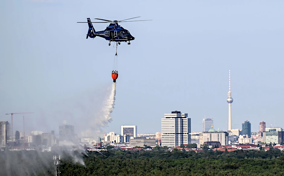 dpatopbilder - Ein Hubschrauber der Bundespolizei wirft Wasser über der Brandstelle im Grunewald ab.  