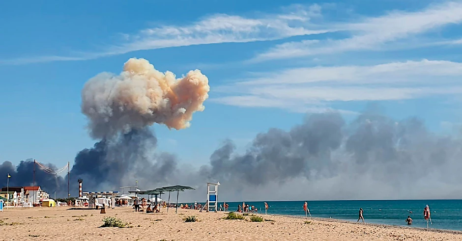 Nach Explosionen auf der russischen Militärbasis Saki sind Rauchsäulen über dem Krim-Strand zu sehen.