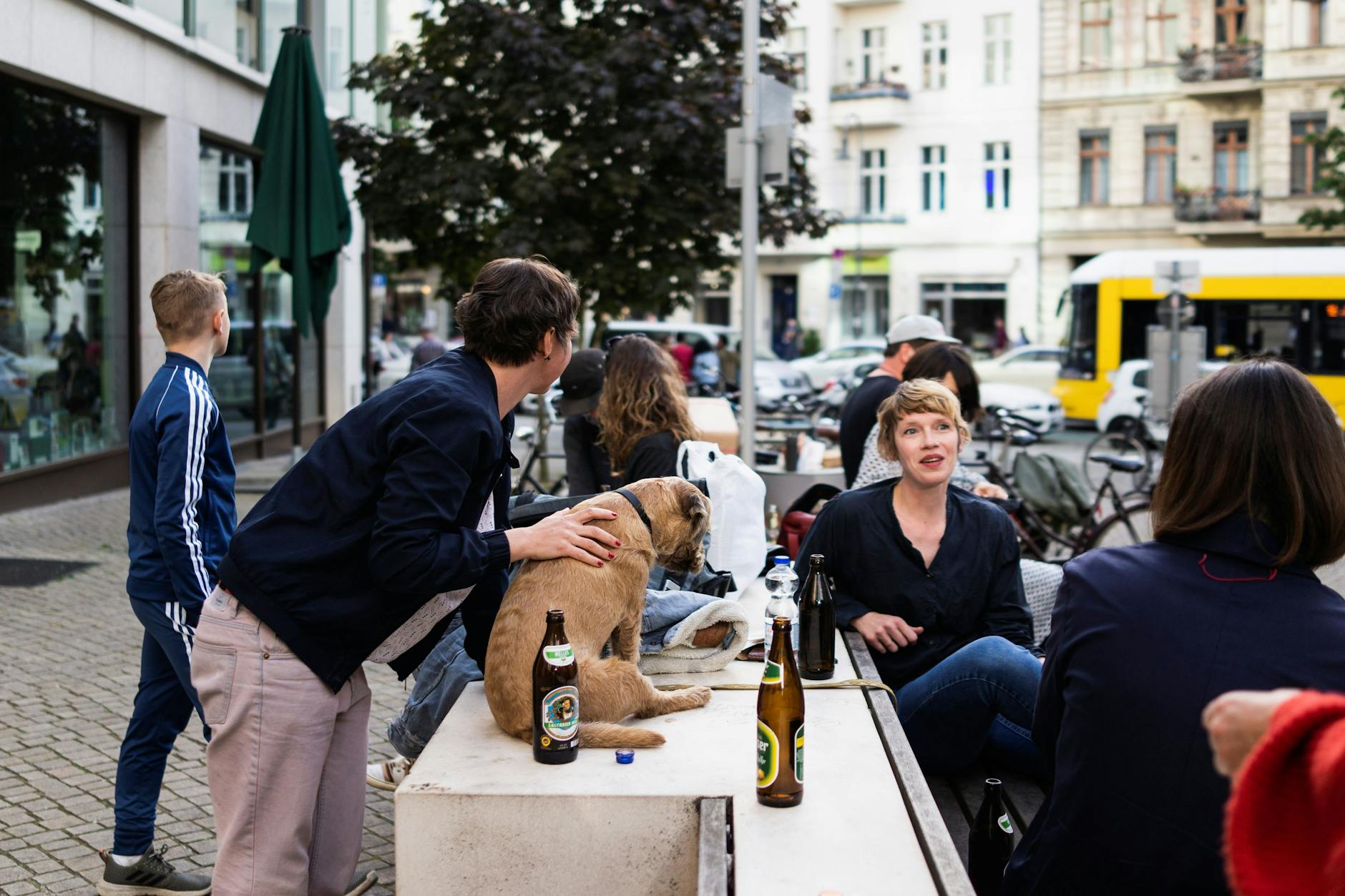 Menschen sitzen draußen an der Kastanienallee in Prenzlauer Berg.