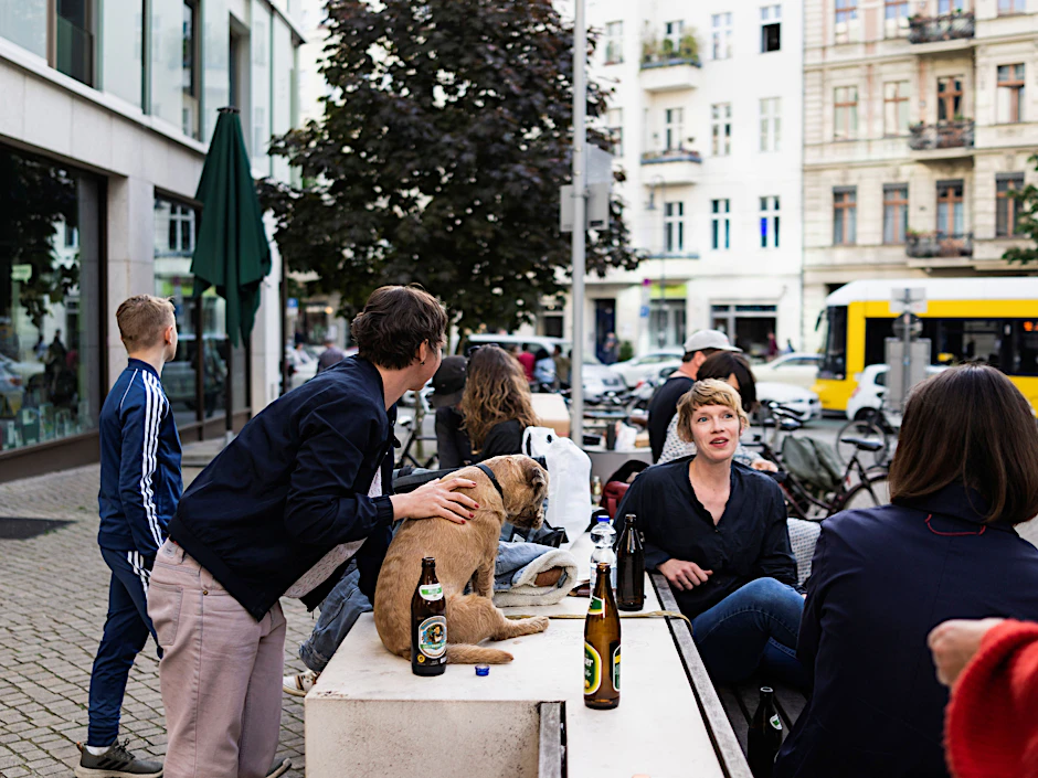 Menschen sitzen draußen an der Kastanienallee in Prenzlauer Berg.