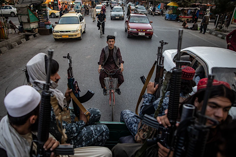 ARCHIV - Taliban-Kämpfer patrouillieren auf der Ladefläche eines Pick-ups in den Straßen von Kabul.