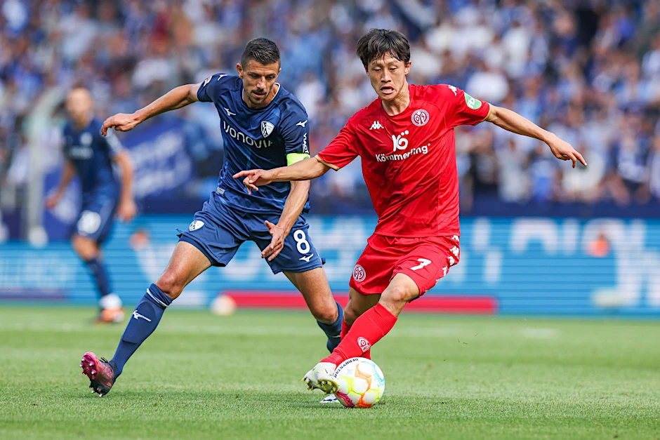Bochums Anthony Losilla (l) kämpft mit dem Mainzer Jae-Sung Lee um den Ball.  