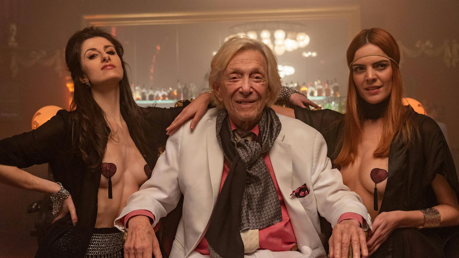 Rolf Eden, wie er sich gerne sah. Hier mit zwei Tänzerinnen, Tara D Arson und Mademoiselle Lola, im Ballhaus Berlin – aus dem Film über sein Leben.