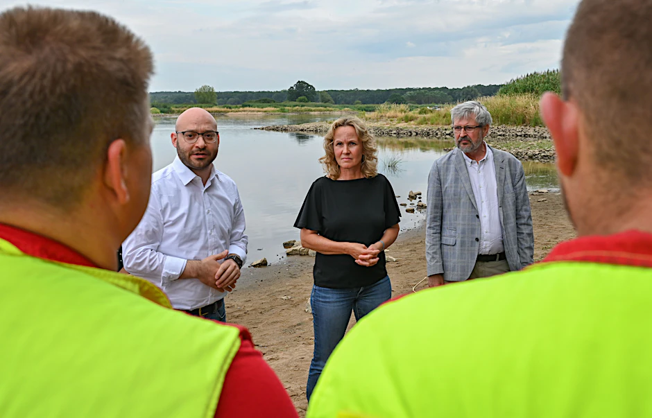 13.08.2022, Brandenburg, Frankfurt (Oder): Steffi Lemke (Bündnis 90/Die Grünen), Bundesumweltministerin, Rene Wilke (l, Die Linke), Oberbürgermeister der Stadt Frankfurt (Oder), und Axel Vogel (r, Bündnis 90/Die Grünen), Umweltminister von Brandenburg, sprechen mit Einsatzkräften über die Umweltkatastrophe am deutsch-polnischen Grenzfluss Oder.