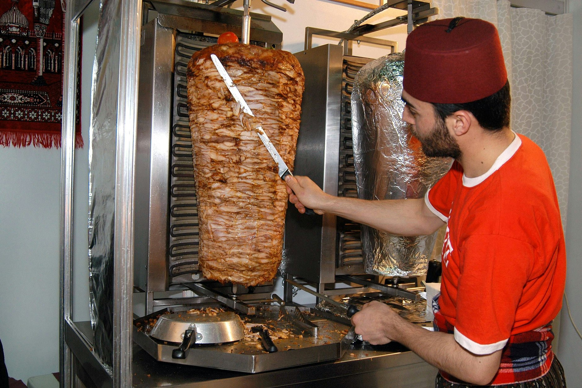 Ein Dönerverkäufer schneidet das Fleisch vom Spieß. Berlin galt lange Zeit als Döner-Hauptstadt.
