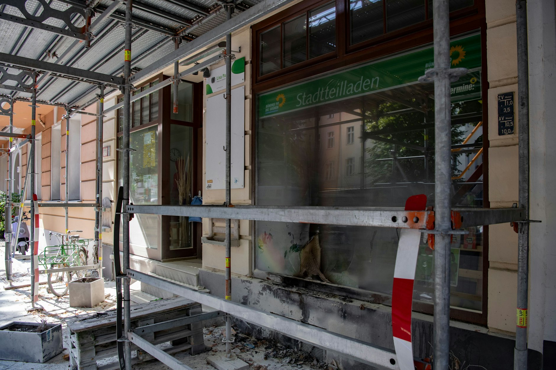 Brandspuren am Wahlkreisbüro von Lisa Paus in einem eingerüsteten Haus an der Charlottenburger Windscheidstraße. Die&nbsp; Schaufensterscheibe ist geborsten.