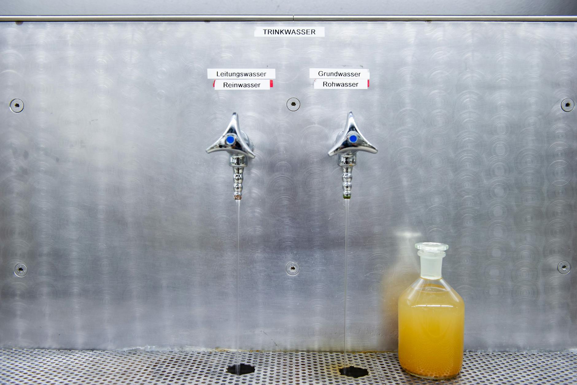 In der Flasche ist Rohwasser. Das kann problemlos getrunken werden, obwohl es Eisen und Mangan enthält. Es schmeckt wie früher bei Oma das Wasser aus einer alten Eisenleitung.