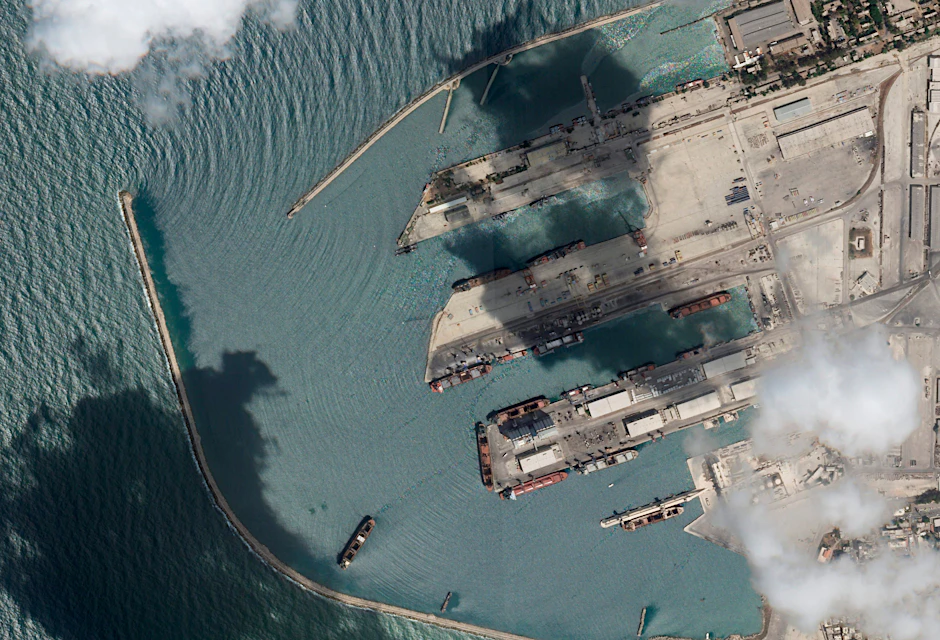 Ein Satellitenbild von Planet Labs PBC zeigt das Frachtschiff unten in der Mitte mit vier weißen Kränen auf dem roten Deck, im Hafen von Tartus.