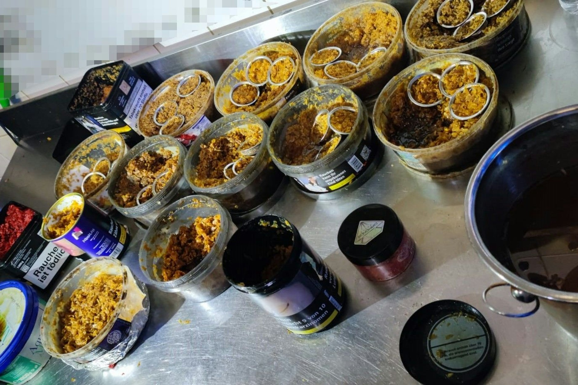 Töpfe voller Shisha-Tabak samt vorbereiteter Pfeifenköpfe.