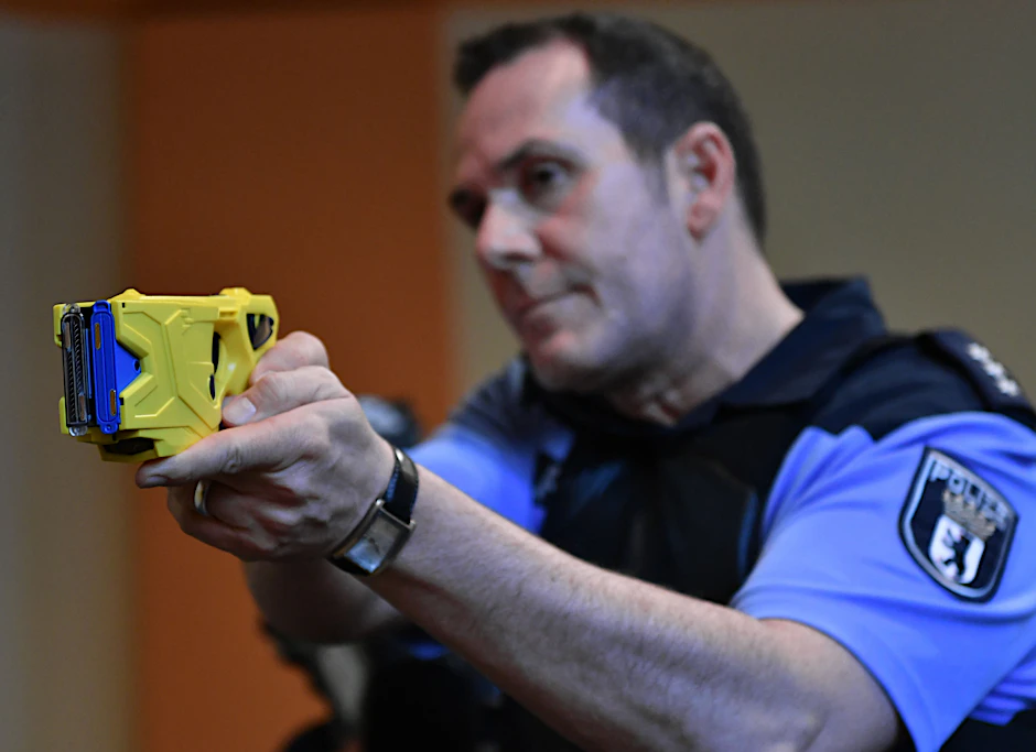 Ein Polizeibeamter zeigt die Handhabung einer Elektroimpulswaffe (Taser).