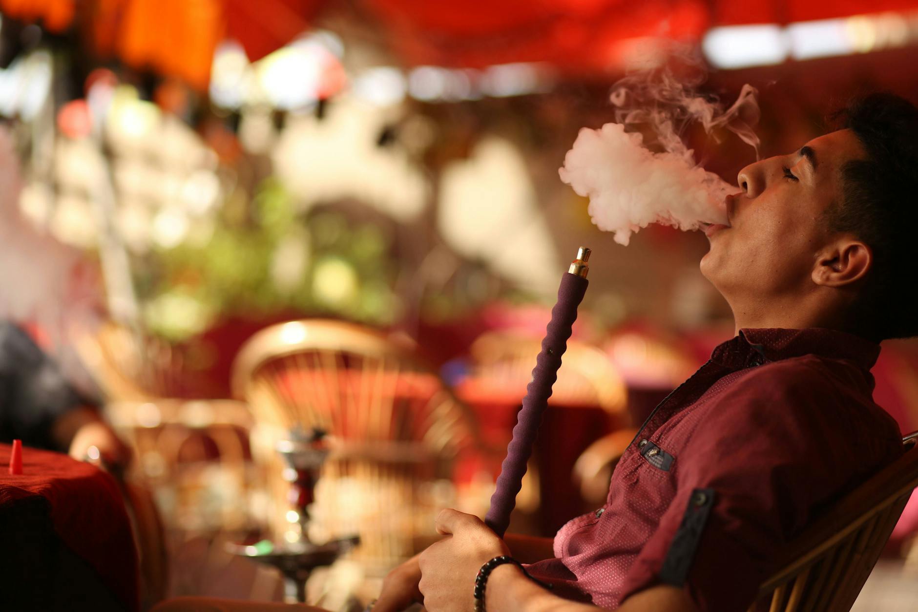 Ein Mann raucht eine Shisha