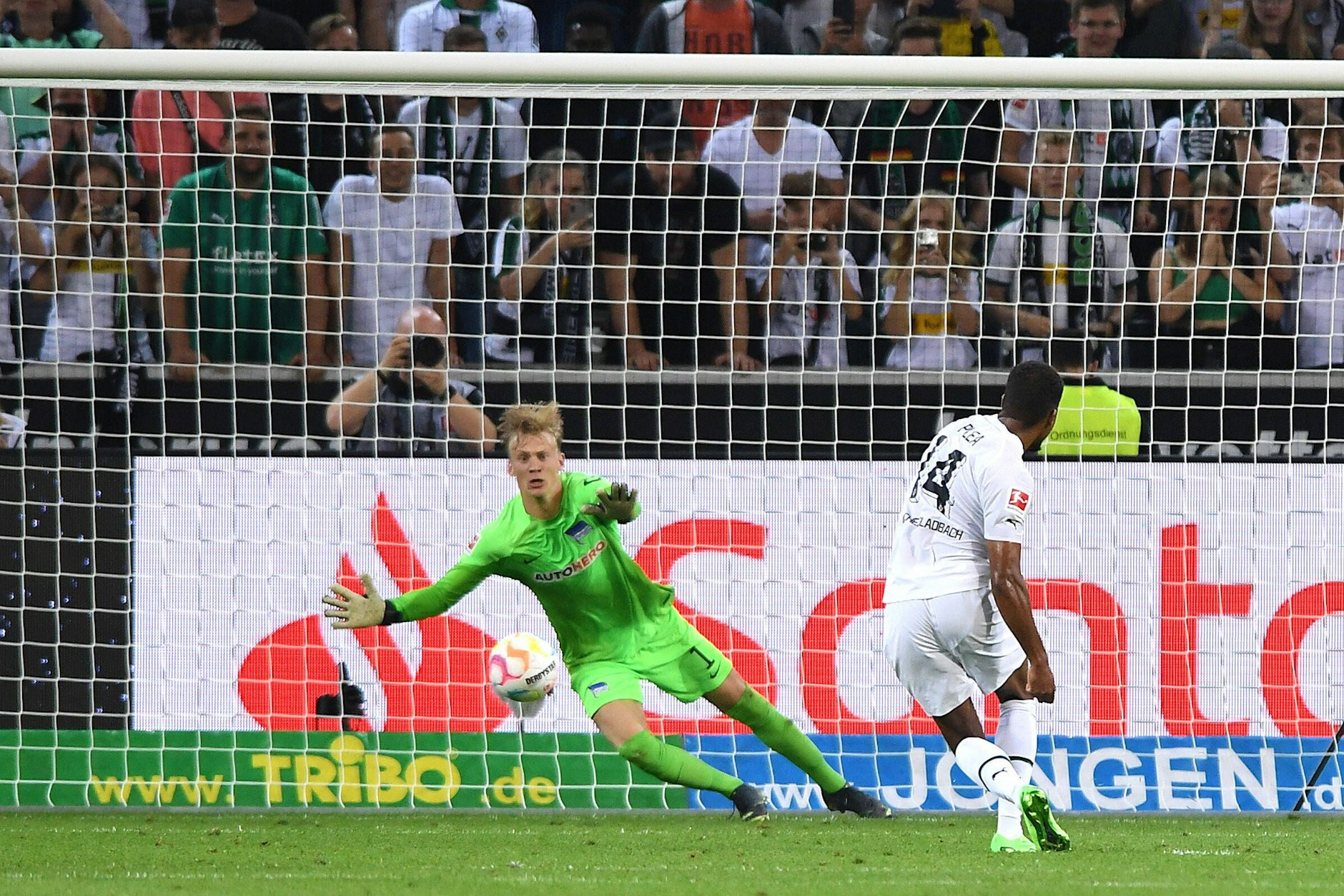 Herthas Keeper Christensen ahnt die richtige Ecke beim Handelfer, doch Gladbachs Plea trifft zum 1:0.