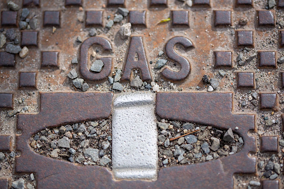 ARCHIV - Der Schriftzug «Gas» steht auf einer Straßenkappe.  mbolbild