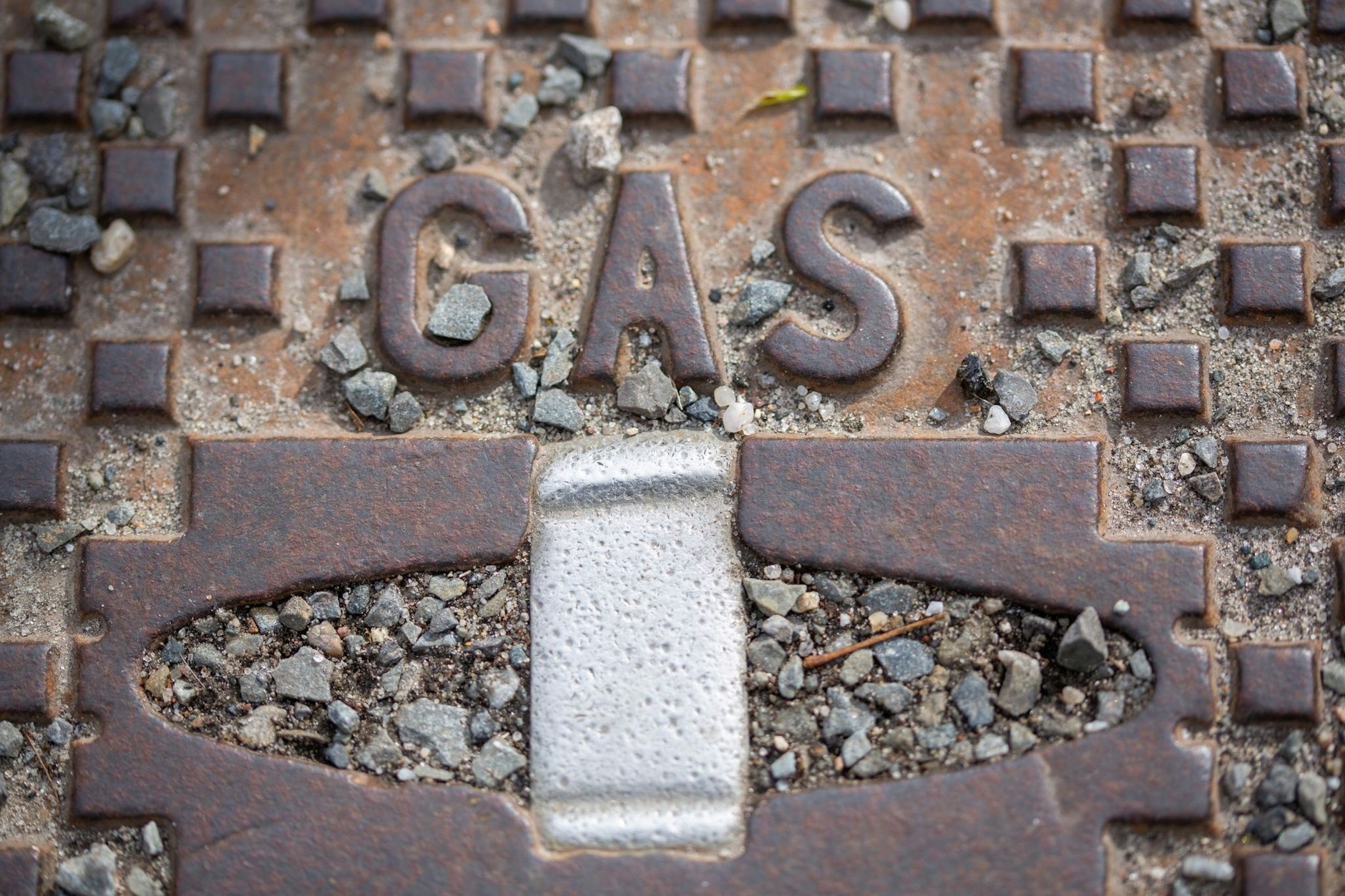 ARCHIV - Der Schriftzug «Gas» steht auf einer Straßenkappe. mbolbild