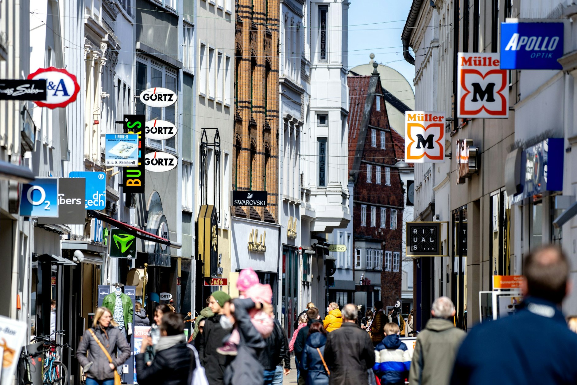 Die Logos zahlreicher Geschäfte hängen an den Fassaden der Häuser in der Innenstadt von Oldenburg. Viele Kommunen suchen nach Wegen, die Stadtzentren attraktiv zu halten und den Leerstand zu vermeiden.
