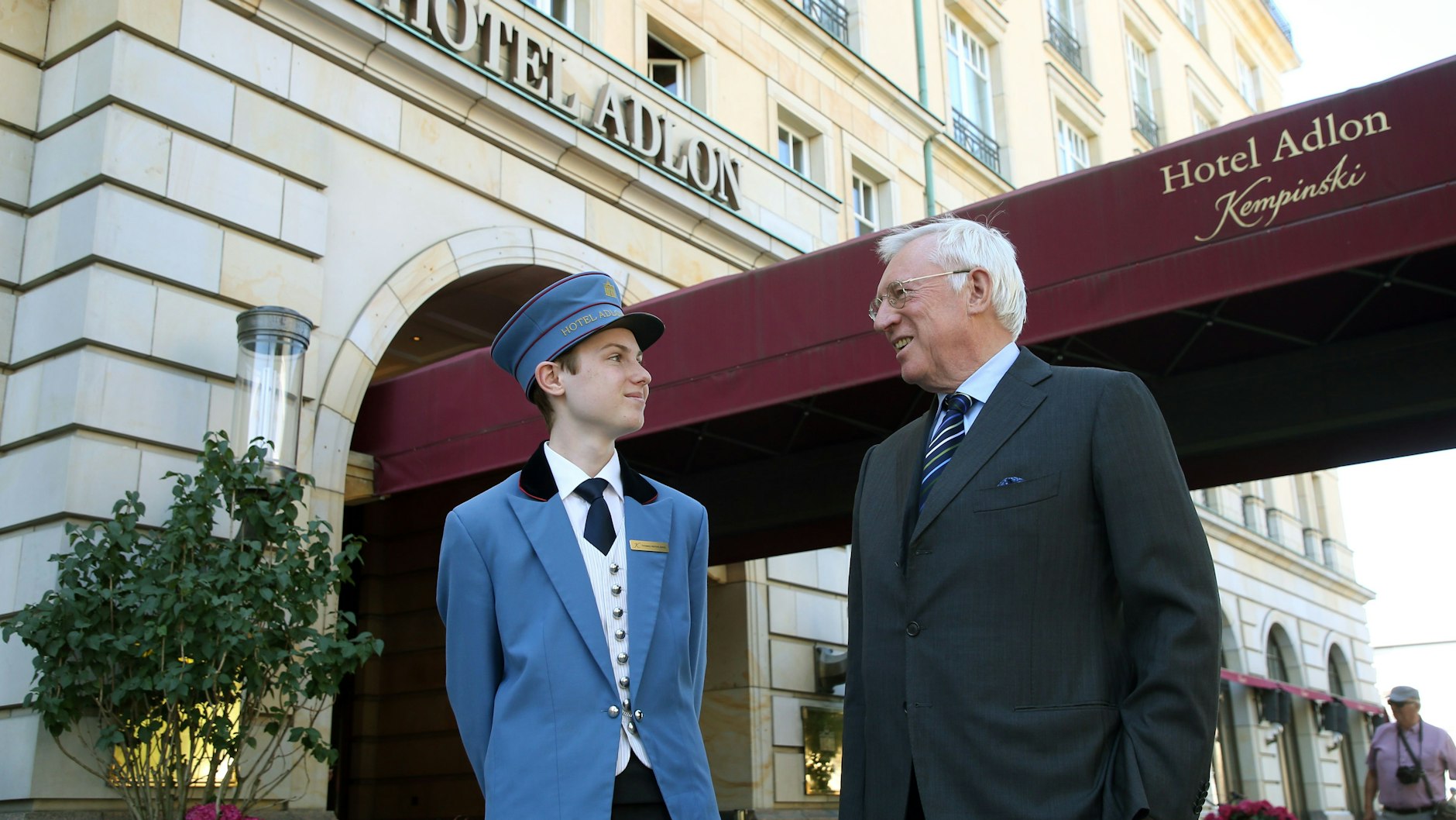 Anno August Jagdfeld, Investor und Eigner des Hotel Adlon, steht vor dem Eingang des Luxushotels und unterhält sich mit einem Pagen.