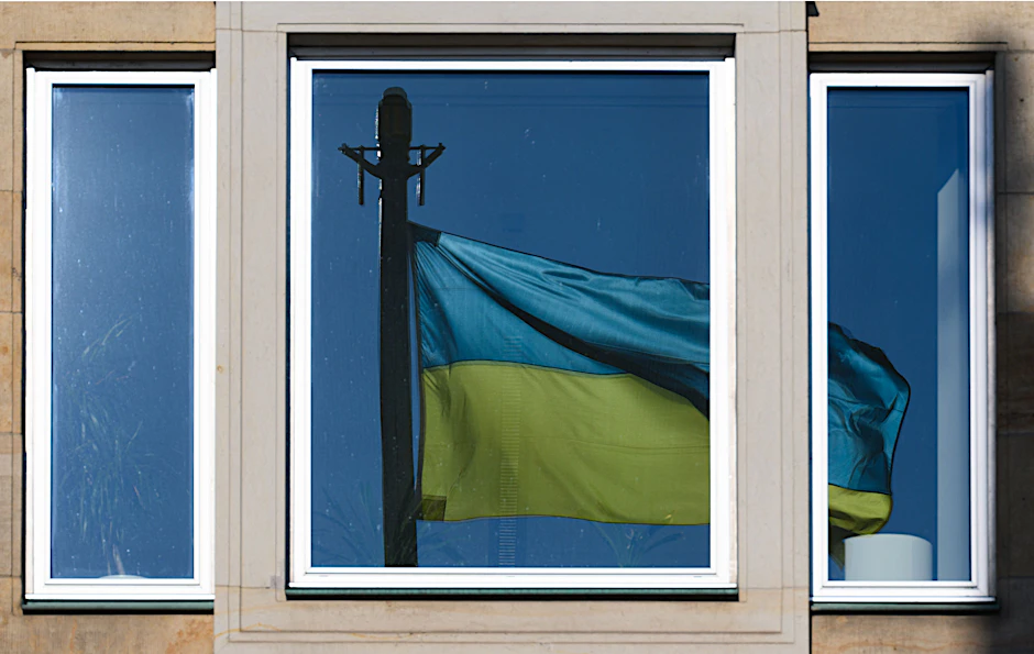 Eine Flagge der Ukraine spiegelt sich in einem Fenster (Symbolbild).