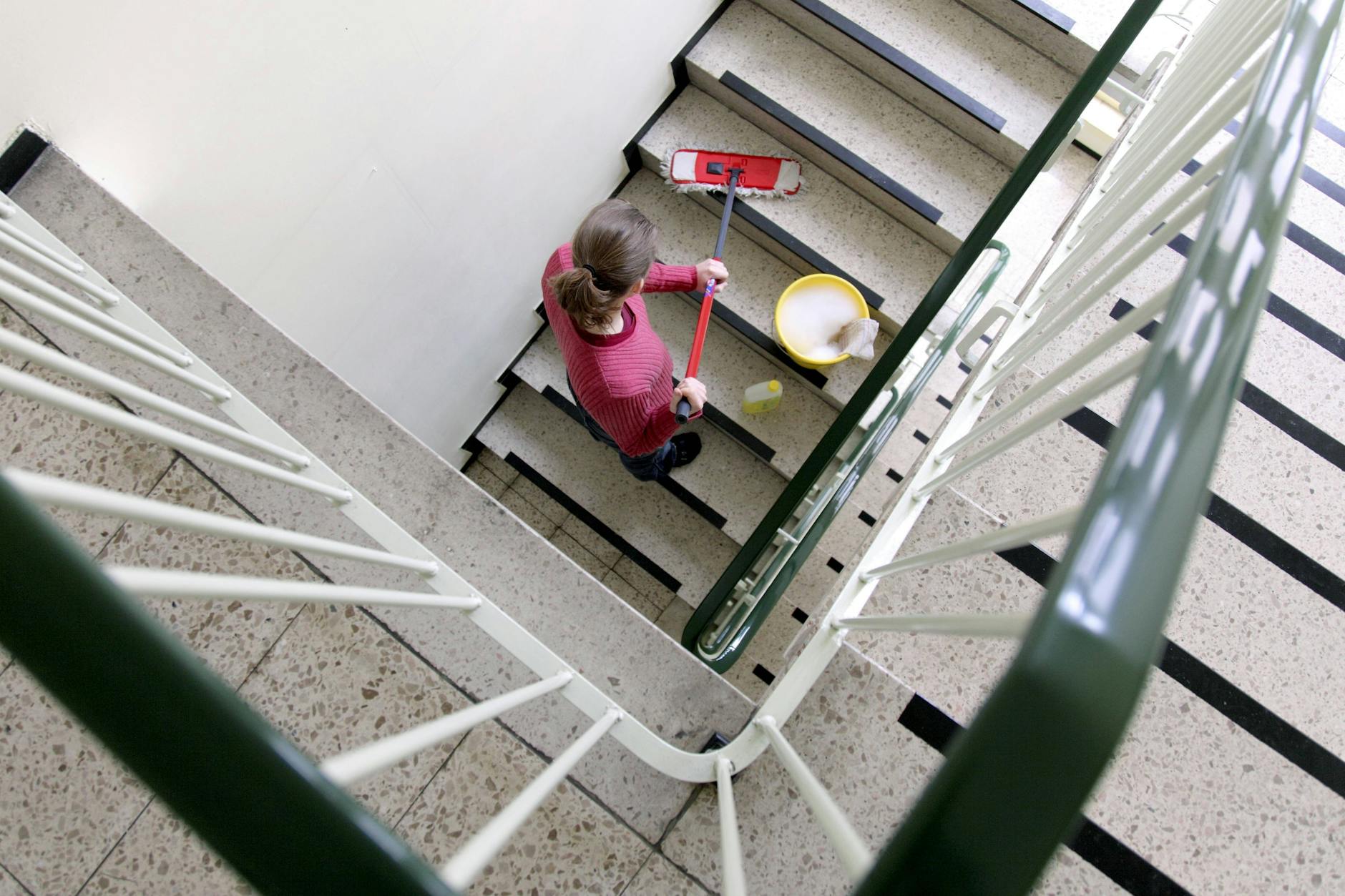 Eine Putzfrau reinigt ein Treppenhaus. Vor allem Frauen und Menschen in Ostdeutschland, die häufig im Niedriglohnsektor beschäftigt sind, bekommen ab Oktober mehr Geld.