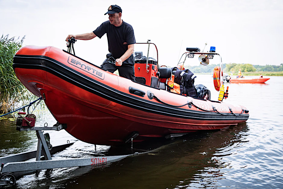 Polnische Feuerwehrleute bergen tote Fische aus der Oder.