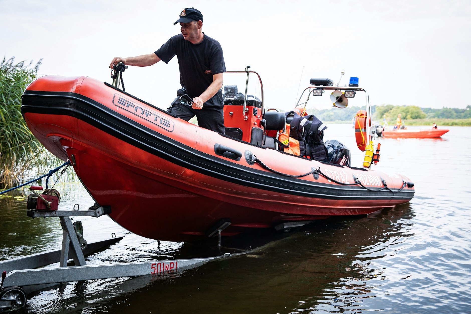 Polnische Feuerwehrleute bergen tote Fische aus der Oder.