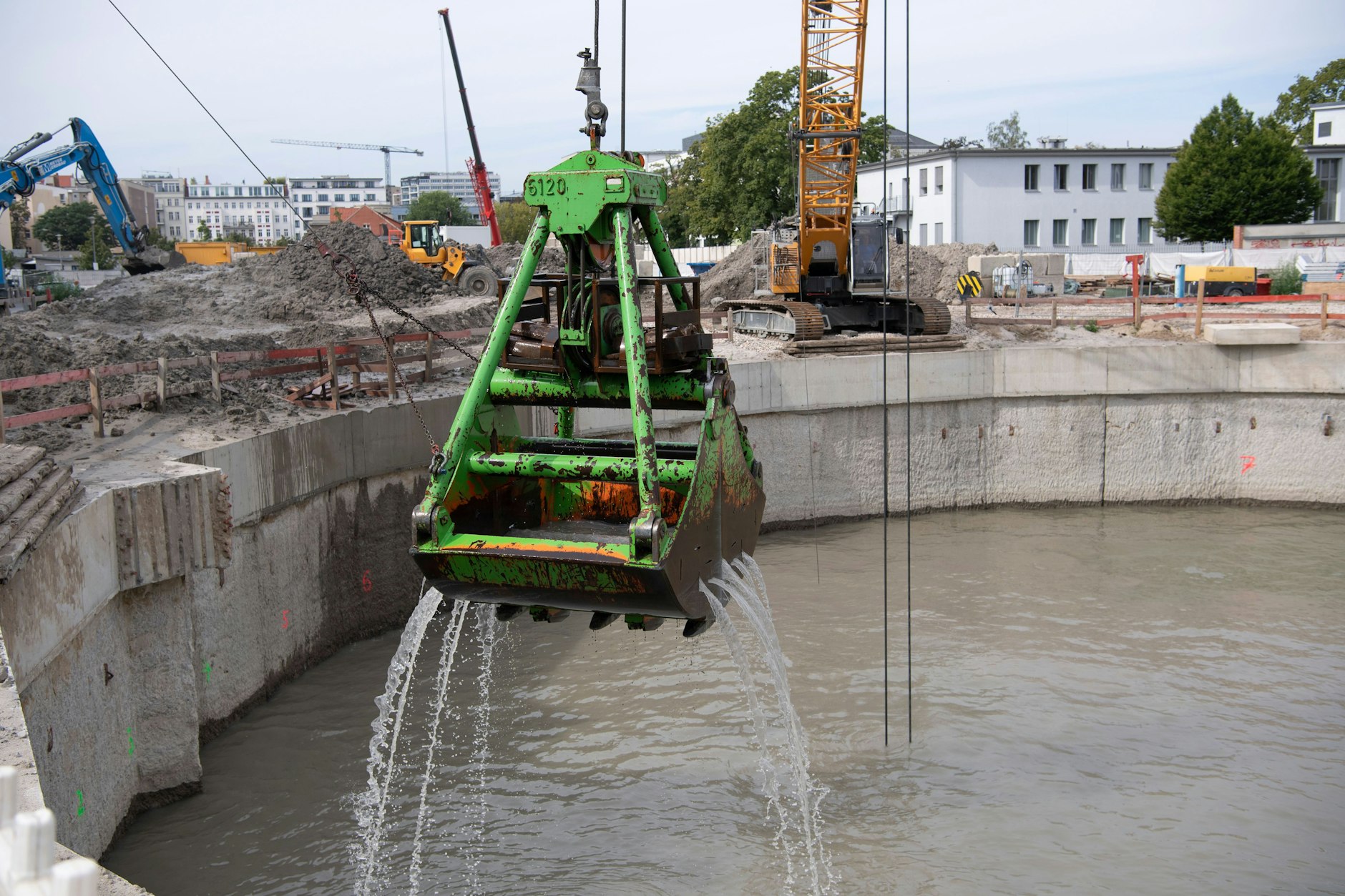 Ein Bagger hebt Schlamm aus dem neuen im Bau befindlichen Stauraumkanal an der Chausseestraße in Berlin-Mitte.