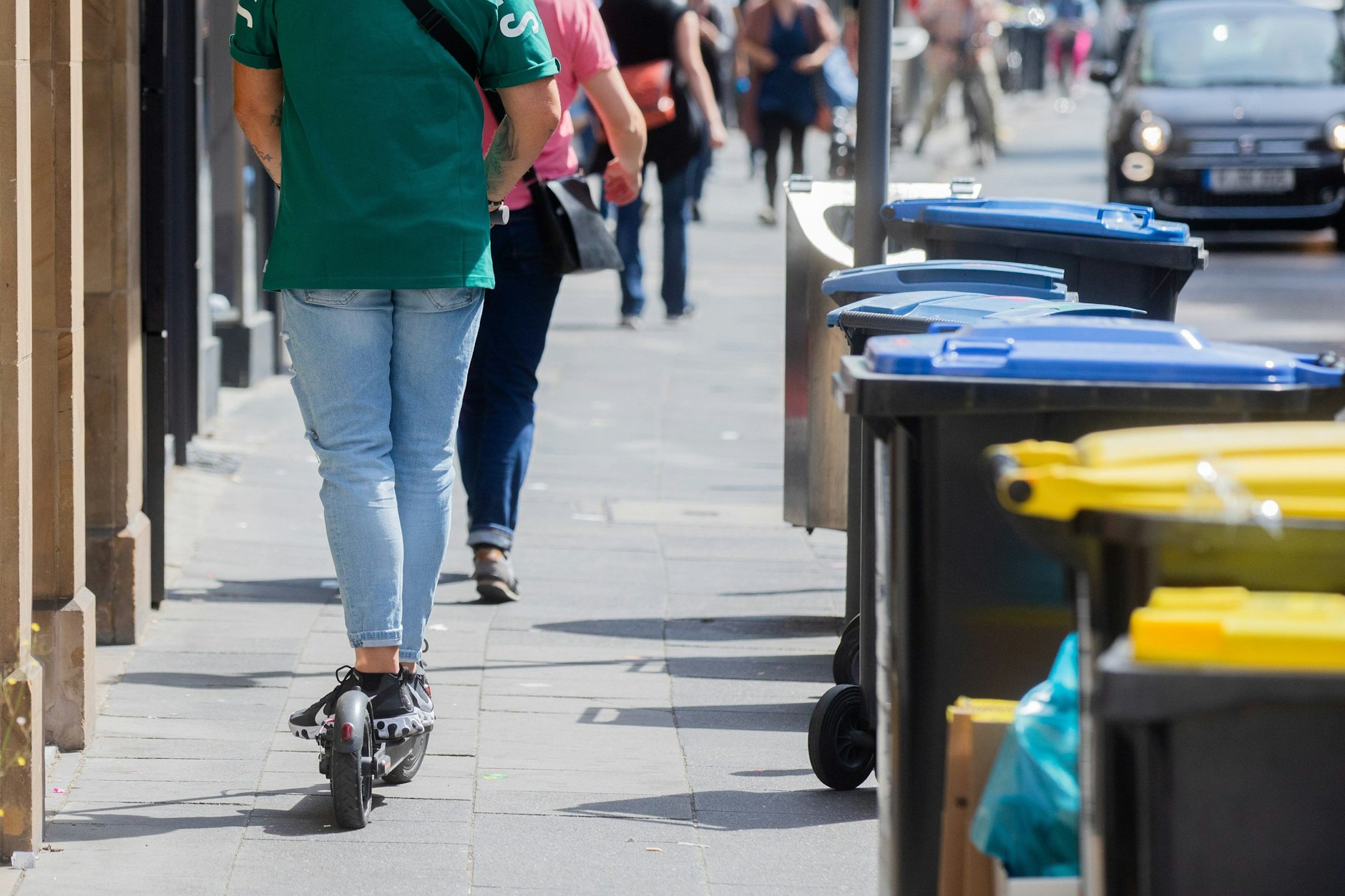 Gefahr im Verzug: Auf einem Berliner Gehweg nähert sich ein E-Scooter von hinten einer Fußgängerin.