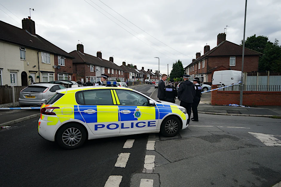 Polizisten stehen am Tatort in Liverpool, wo ein neunjähriges Mädchen von einem Unbekannten erschossen wurde.