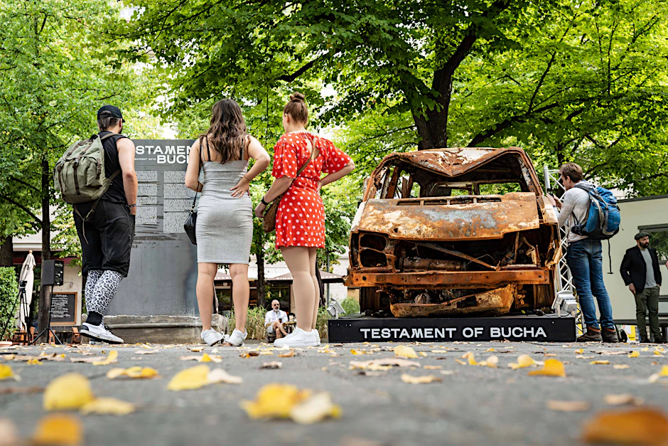 Besucher der Ausstellung „Testament von Bucha“ am George-Grosz-Platz am Kurfürstendamm